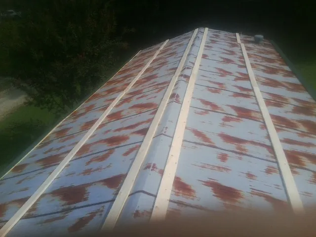 Rusted metal roof panels with new wood purlins before replacement — Storm Damage Roof Repair in Hankamer by Roofing Brothers