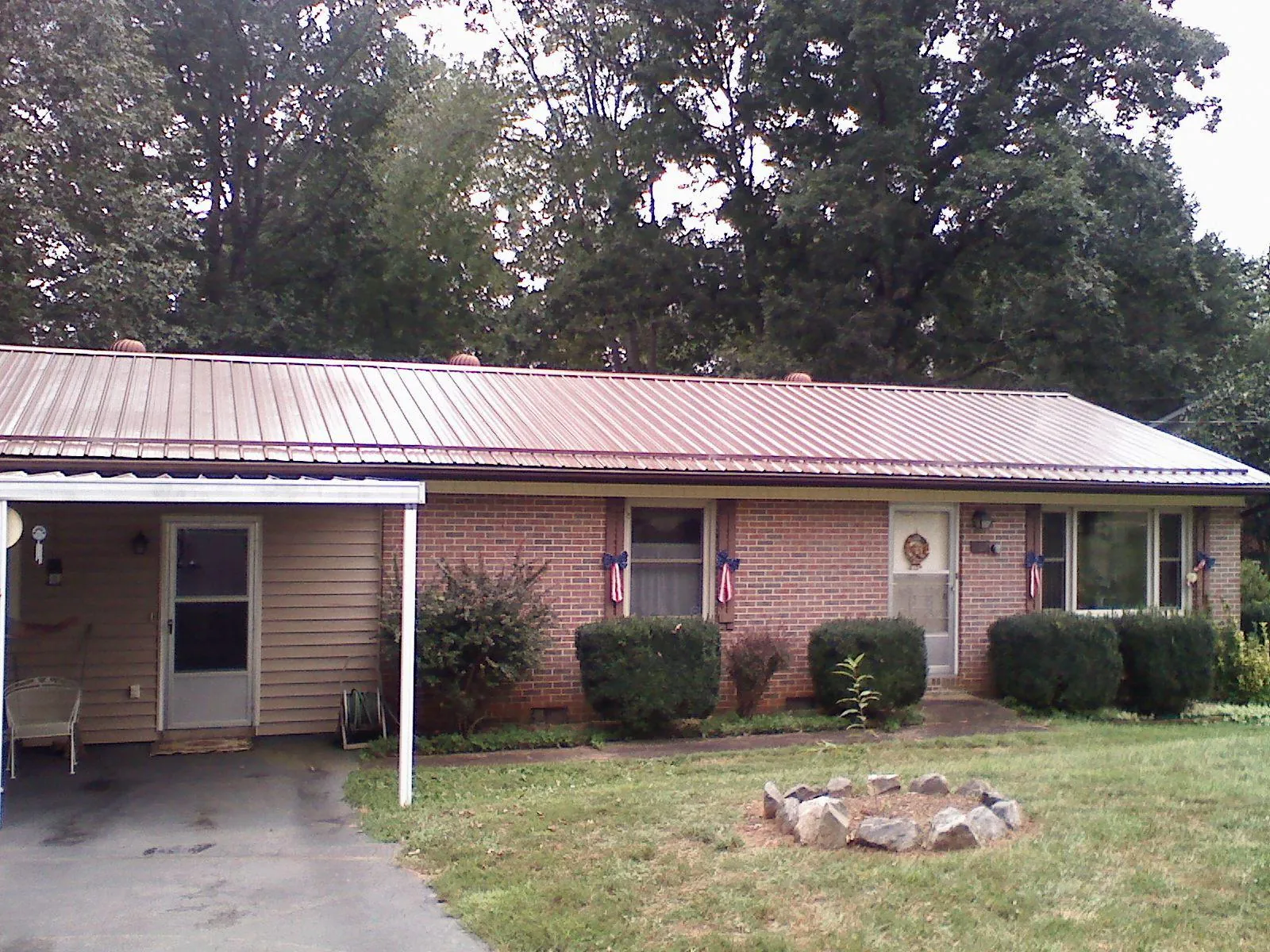 Bronze metal roof and carport on a brick ranch home — Roof Repair work by our crew in Hankamer