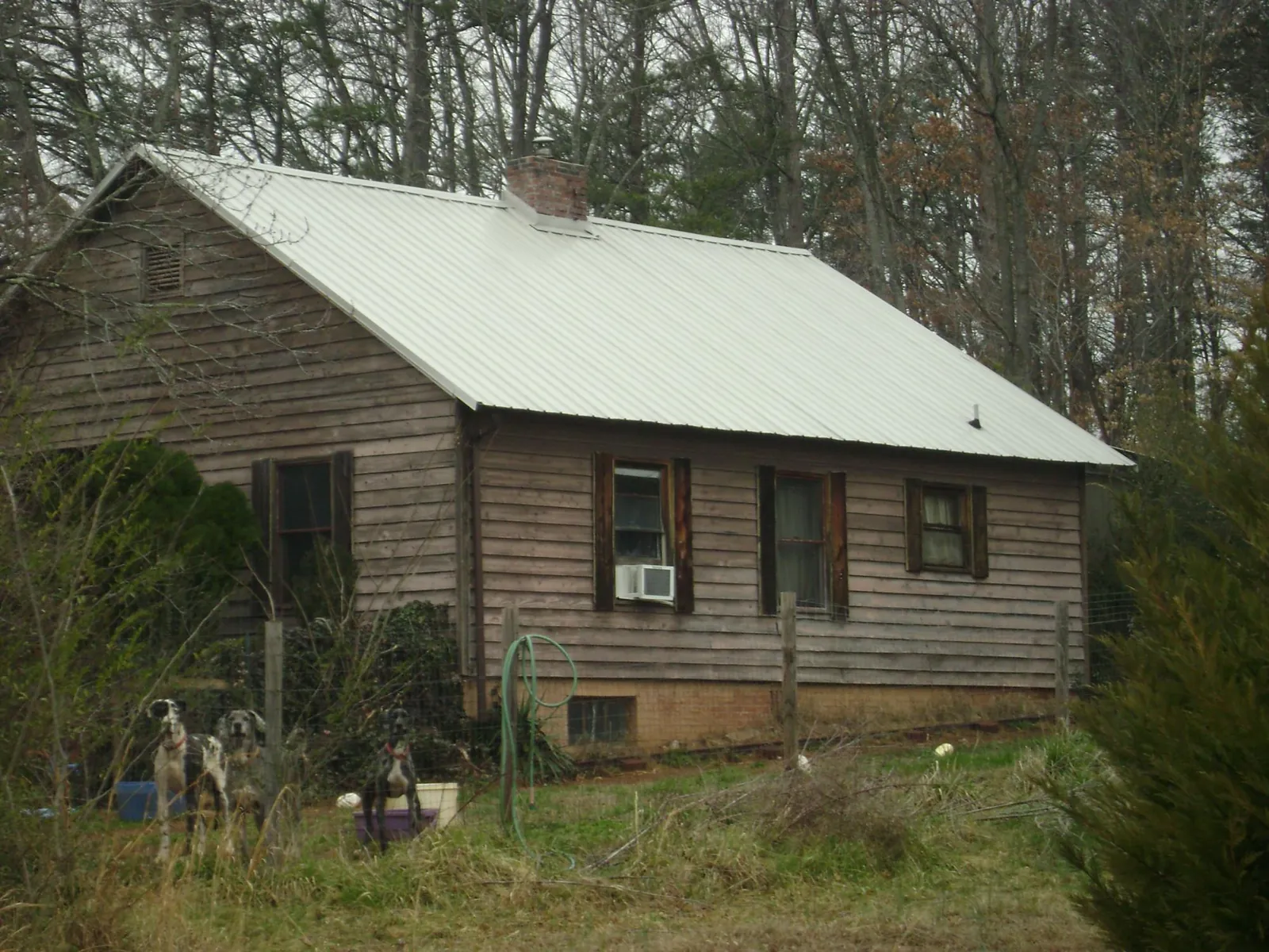 White metal roof on an old wood sided farmhouse, from a Metal Roof Installation job in Hankamer